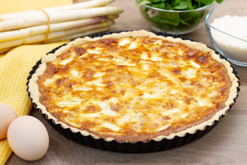 Tart with white asparagus, prosciutto and cheese on shortcrust pastry