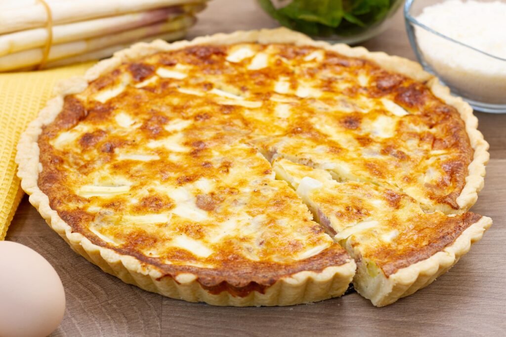 Tart with white asparagus, prosciutto and cheese on shortcrust pastry