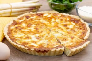 Tart with white asparagus, prosciutto and cheese on shortcrust pastry